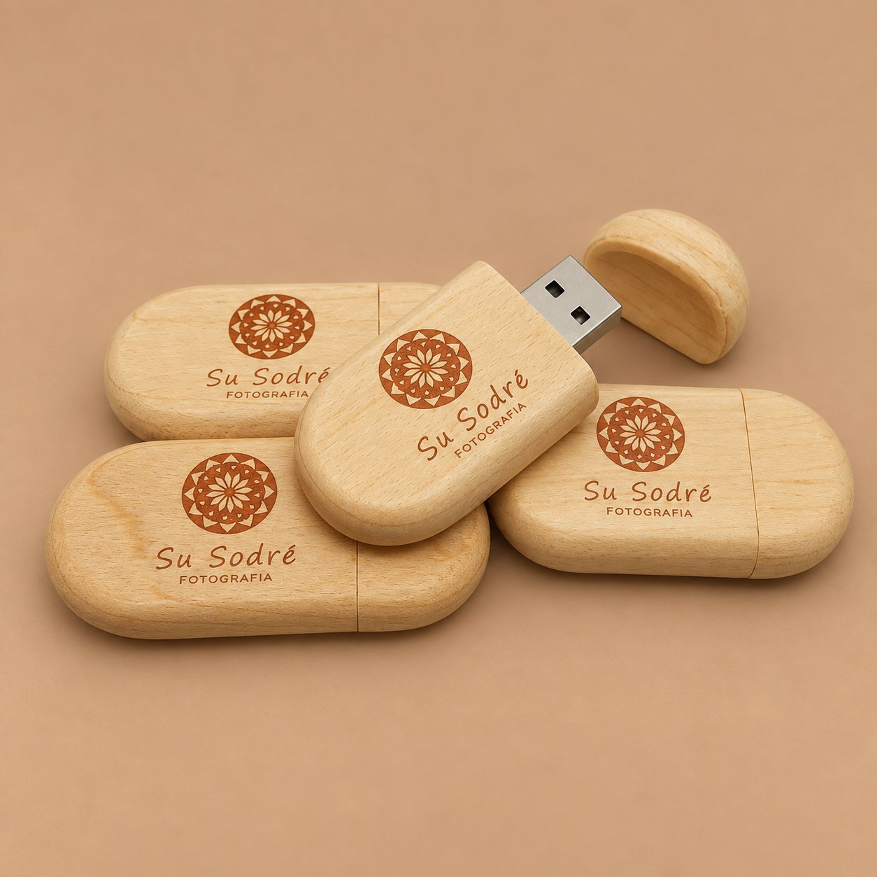 Four wooden USB drives, each engraved with the same simplified Su Sodre Fotografia mark, showing how a clean wordmark scales across a production run.
