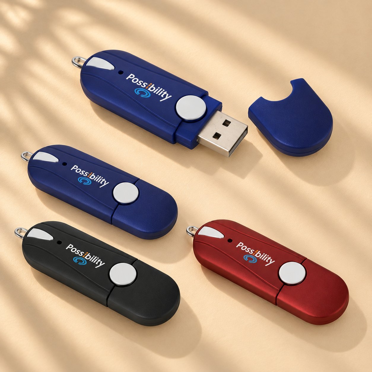 Quatre clés USB personnalisées de différentes couleurs (bleu marine, noir, rouge) estampillées du logo Possibility, montrant les options de marque et de couleur hospitalières ou départementales.