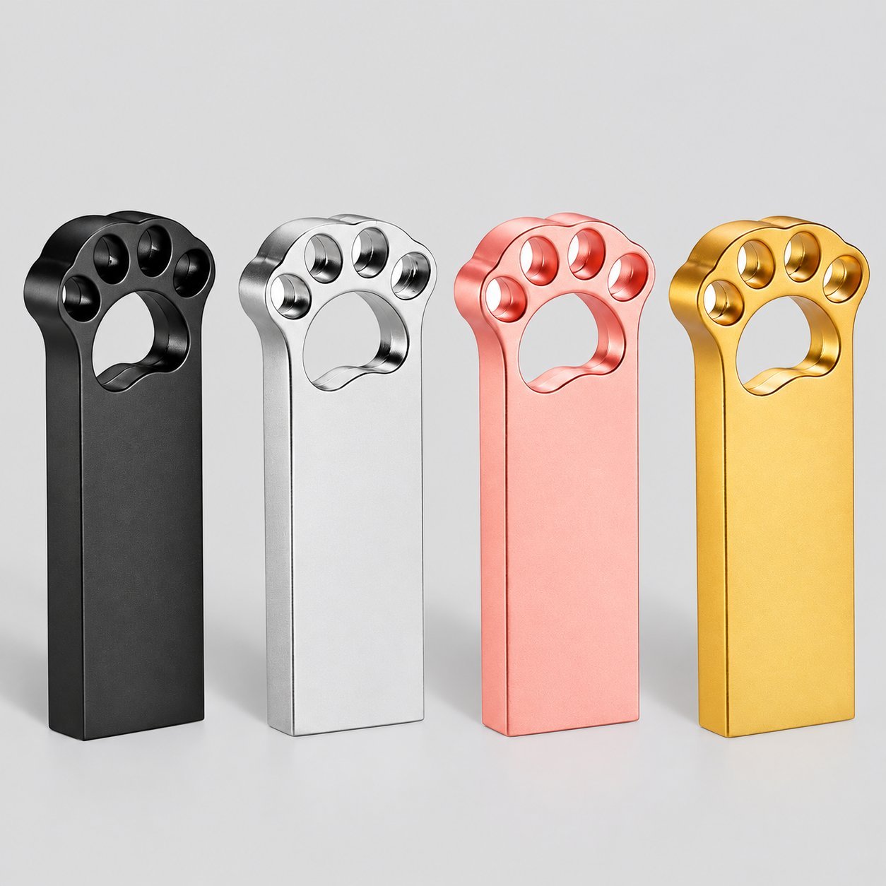Cuatro memorias USB de metal en forma de pata de aleación de zinc en acabados negro, plata, oro rosa y oro, mostradas una al lado de la otra como exhibición de estilo de metal terminado para compradores que comparan factores de forma premium de USB de metal.