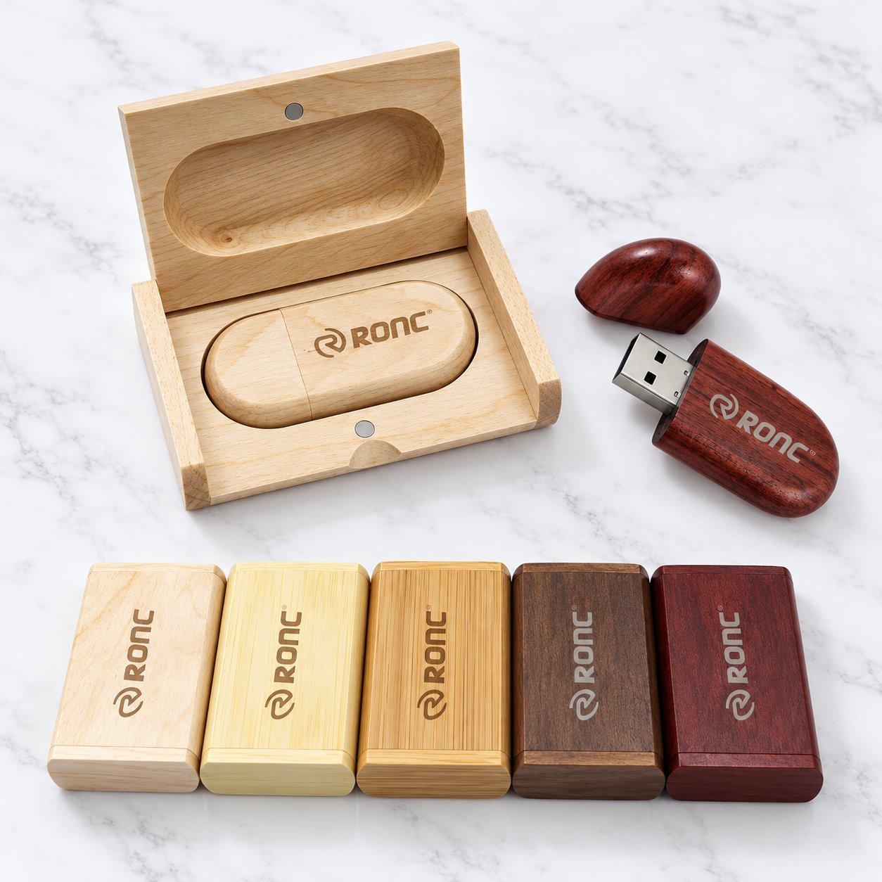 Two light-bamboo wooden USB flash drives with separate bamboo end caps — one engraved with the 'Concepts in Animal Welfare / WSPA' logo, the other with the 'ASUS' wordmark and a QR code, illustrating the print and engraving methods used to reproduce a brand logo on bamboo across orders.