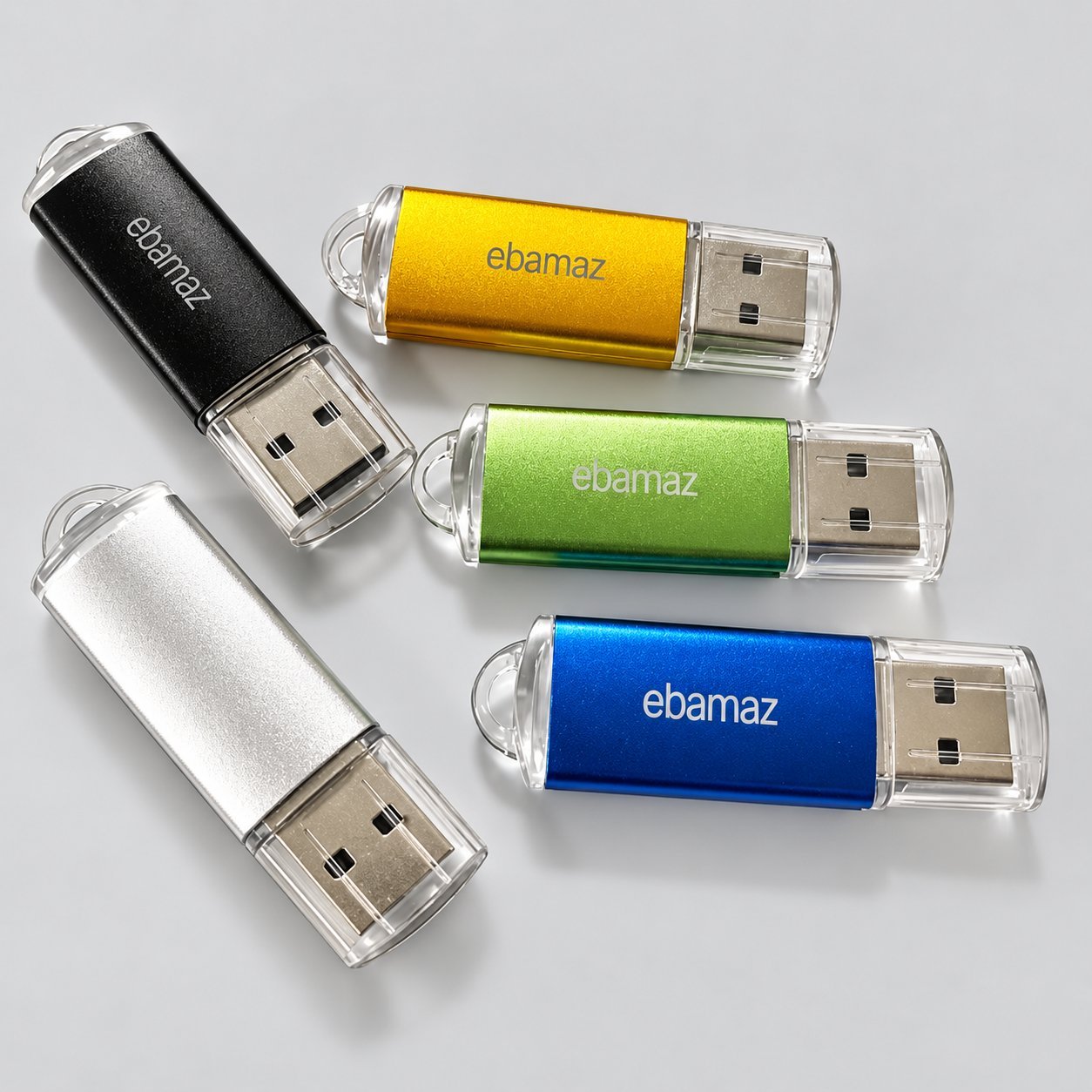 Ebamaz logosu basılı ve konnektör uçlarında şeffaf kapaklı, siyah, sarı, yeşil, mavi ve gümüş kaplamalı beş plastik USB bellek; düşük kapasiteli promosyon siparişleri için tipik giriş seviyesi renkli plastik USB çubuğunu gösterir.