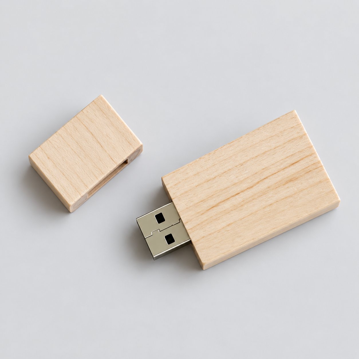 Two angular light-maple wooden USB drives with the cap removed and one showing the USB-A connector fully seated, illustrating the cap-on / cap-off seating behavior and the wood-housing clearance around the connector pins.