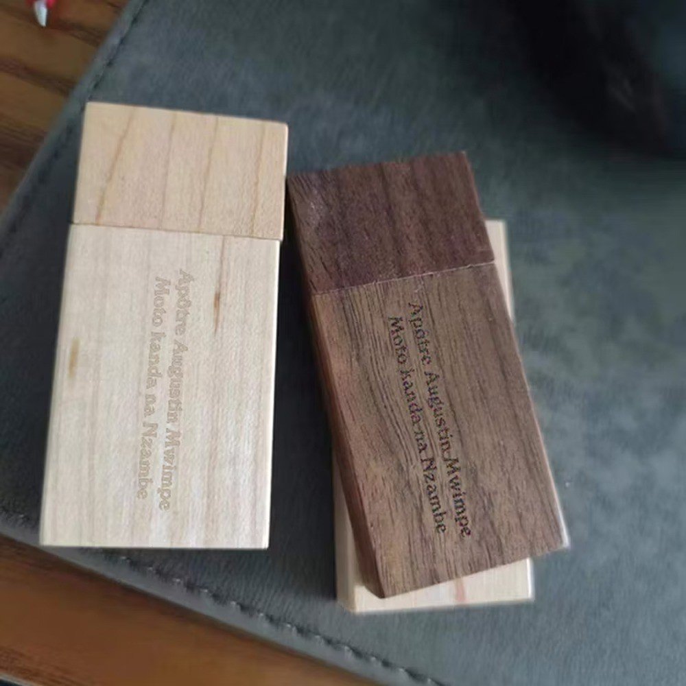 Light and dark engraved wooden USB drives on a desk surface