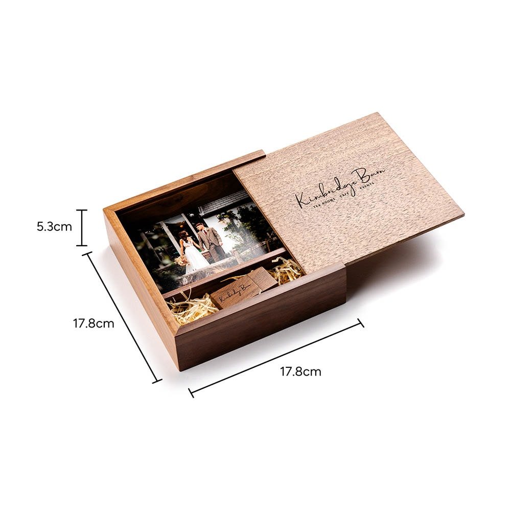 Walnut slide-top wooden photo box measuring 17.8 x 17.8 x 5.3 cm, lid part-opened to show a wedding photo print and a dedicated slot holding an engraved wooden USB drive, with dimension arrows labeling all three measurements.